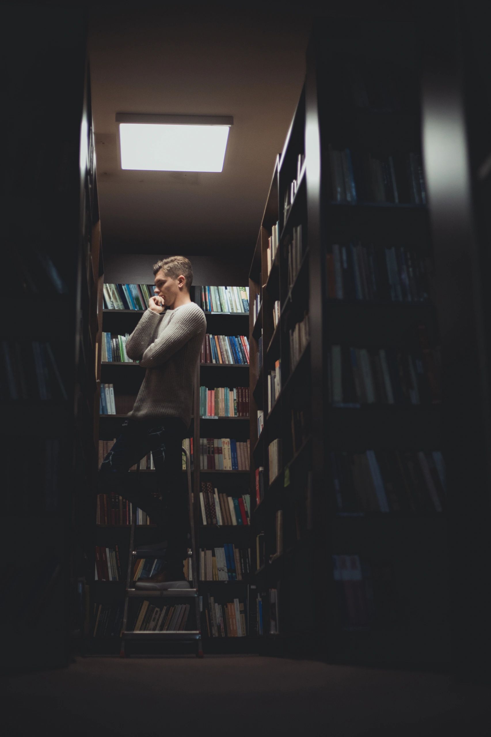 Writer browsing bookshelves in a library