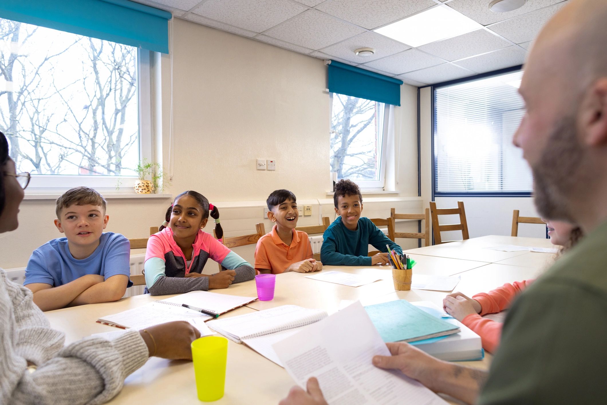 Students and educators gathered around a classroom table