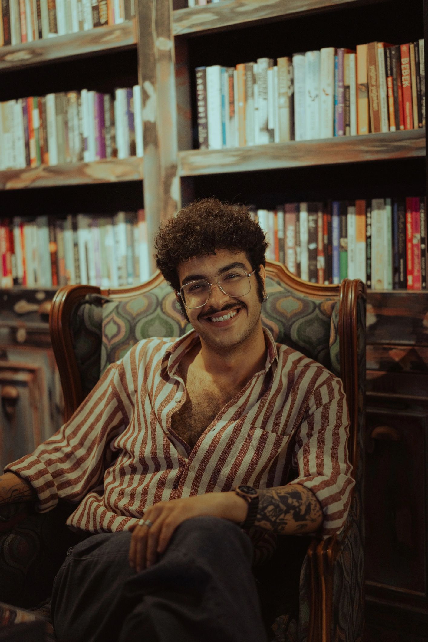 Smiling author seated in a library armchair