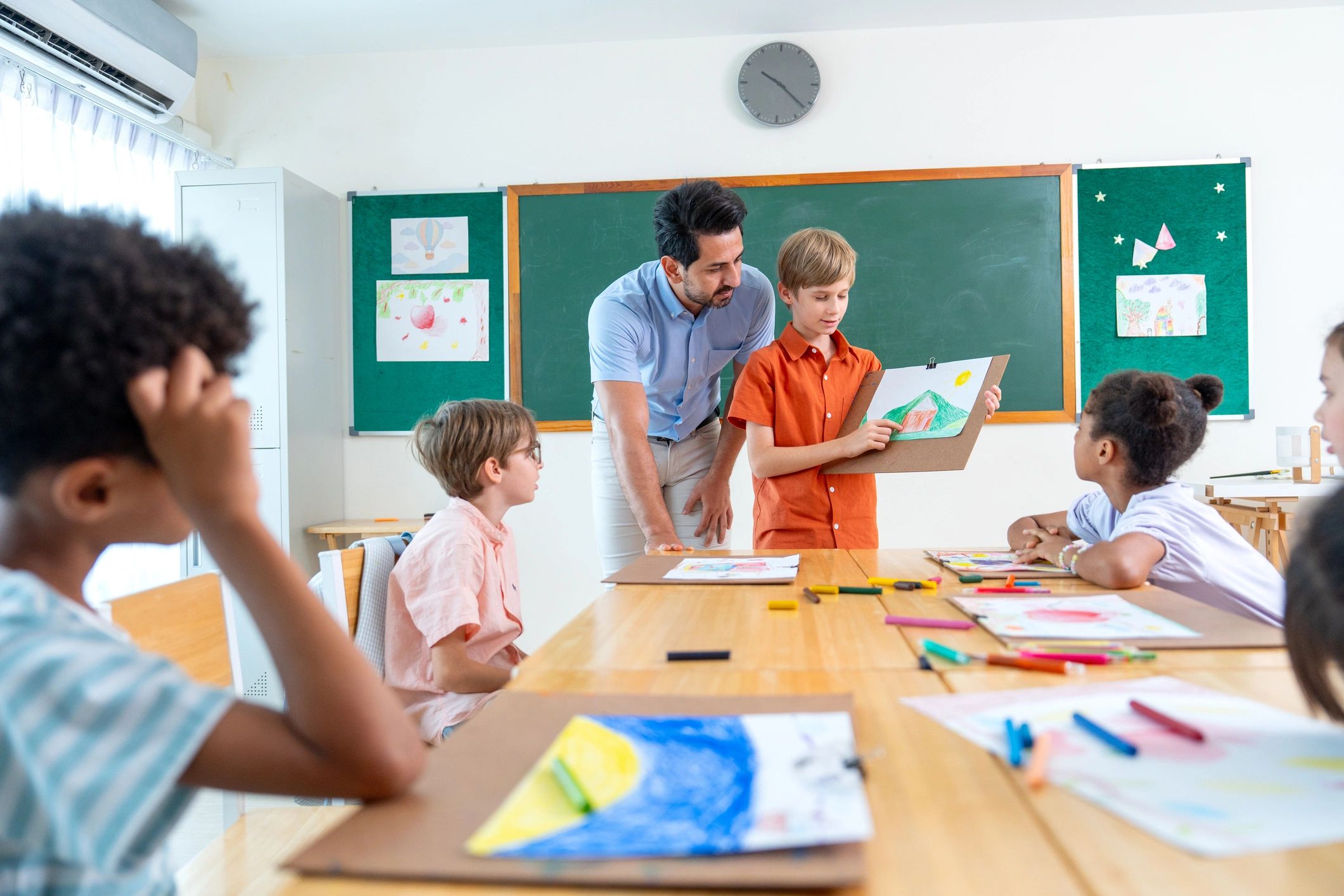 Teacher presenting artwork in a classroom