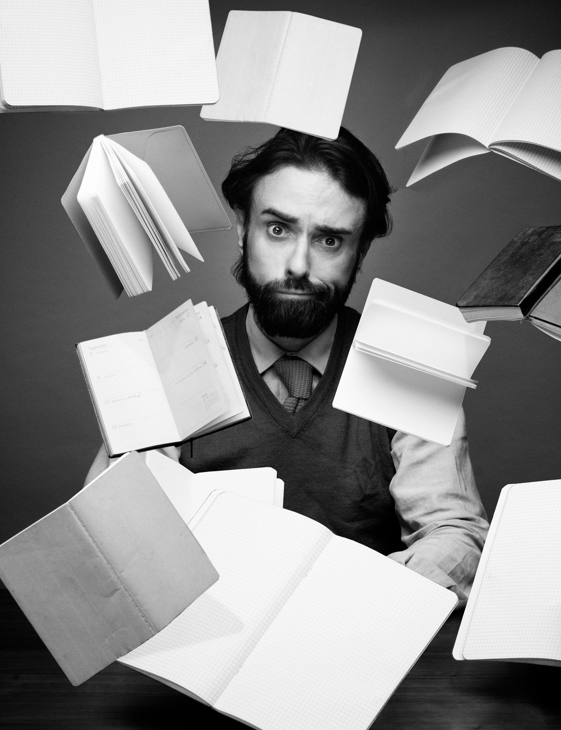 Creative writer surrounded by notebooks at a desk